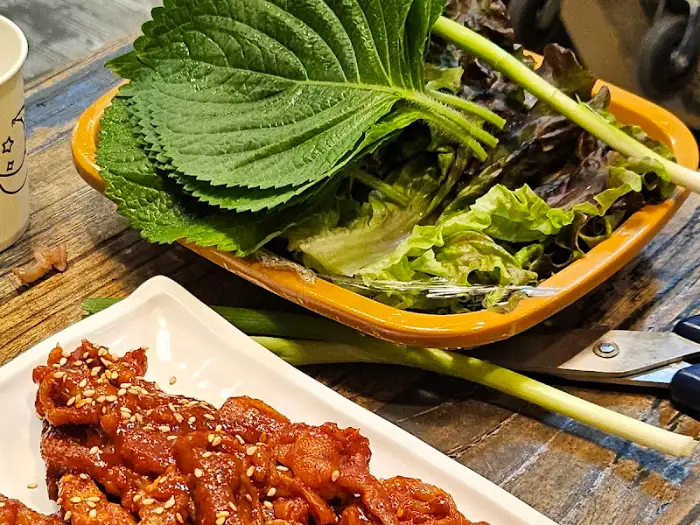 싱싱한 깻잎과 쌈 채소가 담긴 주황색 그릇