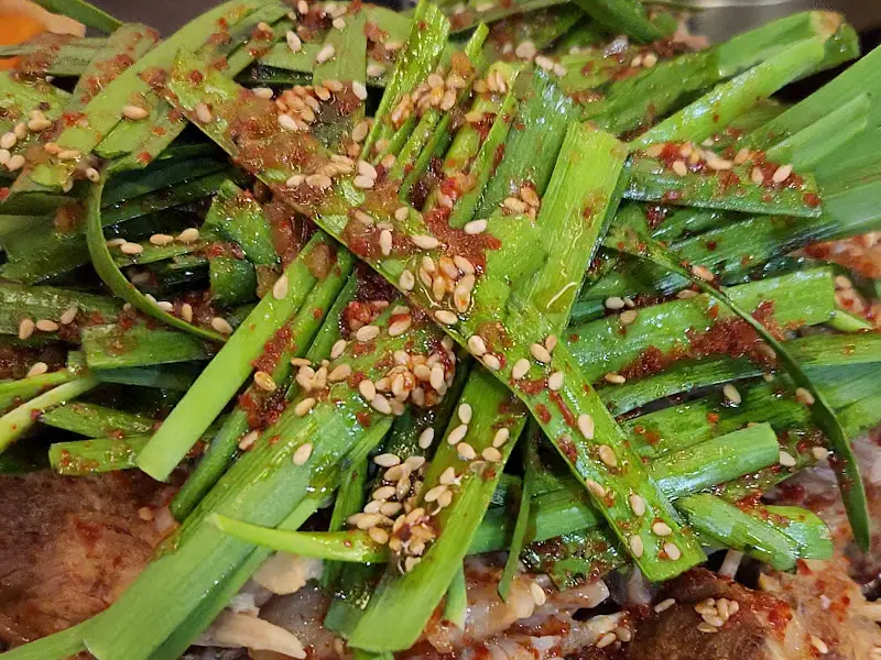 부추 위에 뿌려진 고춧가루와 깨가 식욕을 자극한다.