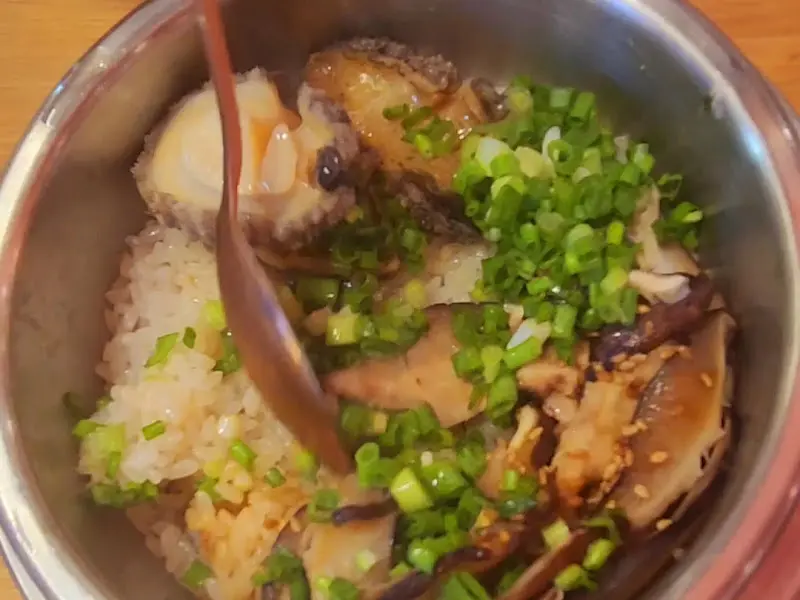 전복솥밥에 특제 소스를 넣는 모습