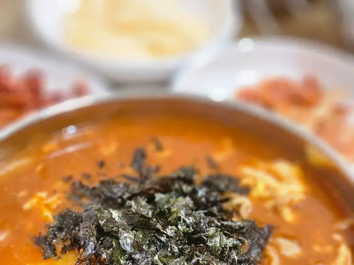 장칼국수의 붉은 국물과 김 가루