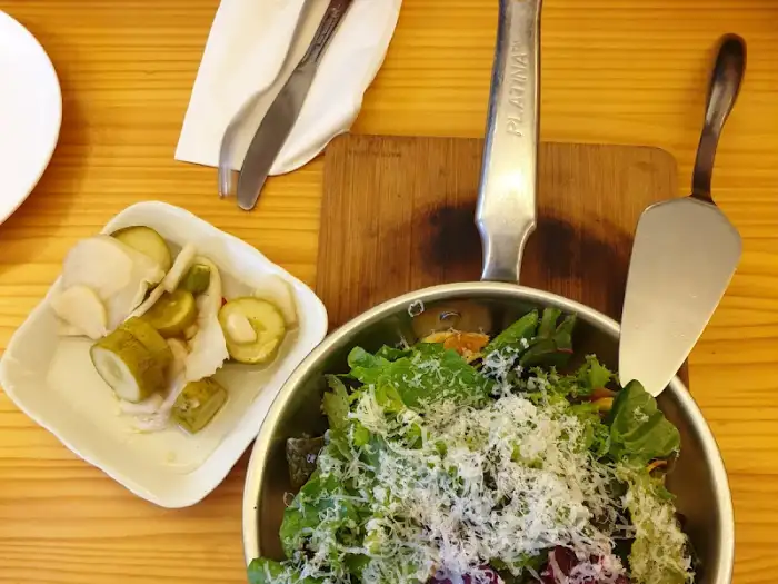 샐러드와 피클, 그리고 피자 도구를 보여주는 모습