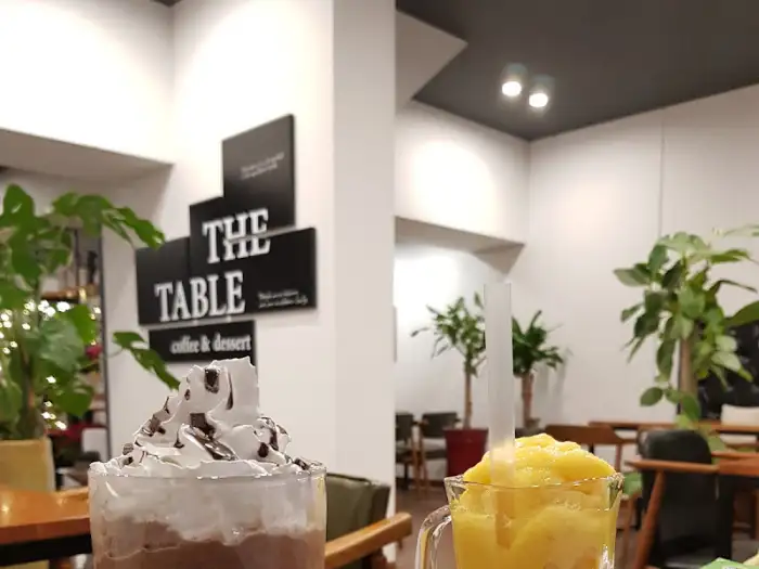 카페 내부의 'THE TABLE' 로고와 음료