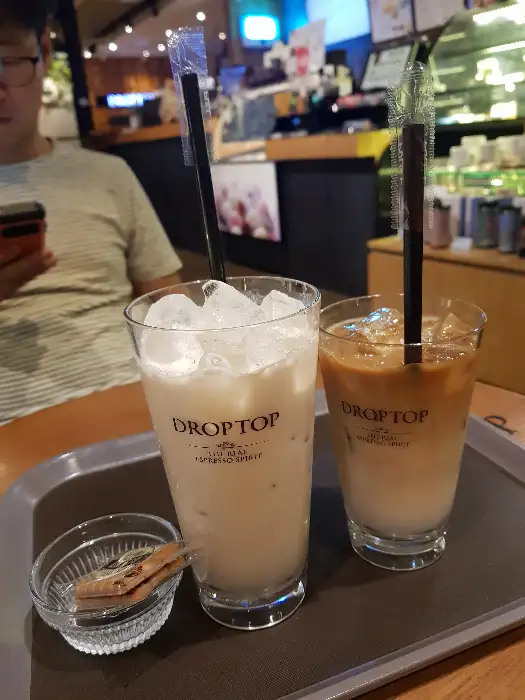 얼음이 가득 담긴 두 잔의 라떼와 작은 유리 그릇에 담긴 무언가