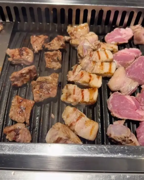 다양한 부위의 고기가 불판 위에서 맛있게 익어가고 있습니다.