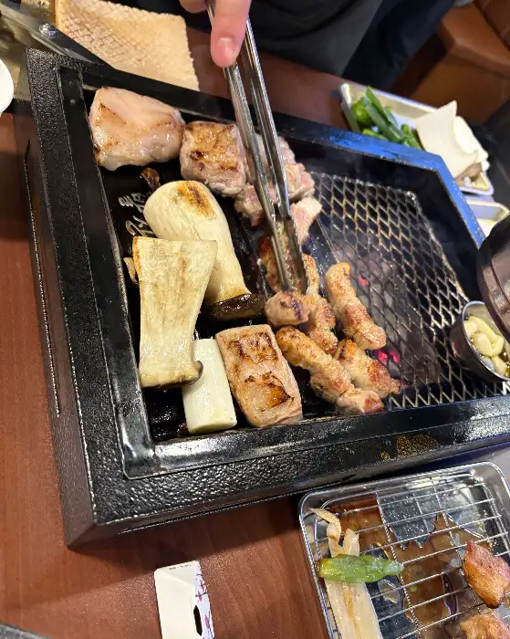 직원분이 집게로 고기를 뒤집는 모습