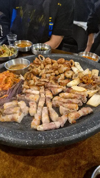 푸짐하게 차려진 막창과 삼겹살, 각종 곁들임 반찬들의 모습