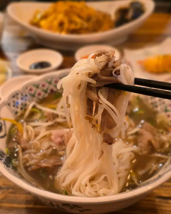 젓가락으로 집어 올린 쌀국수 면과 고기