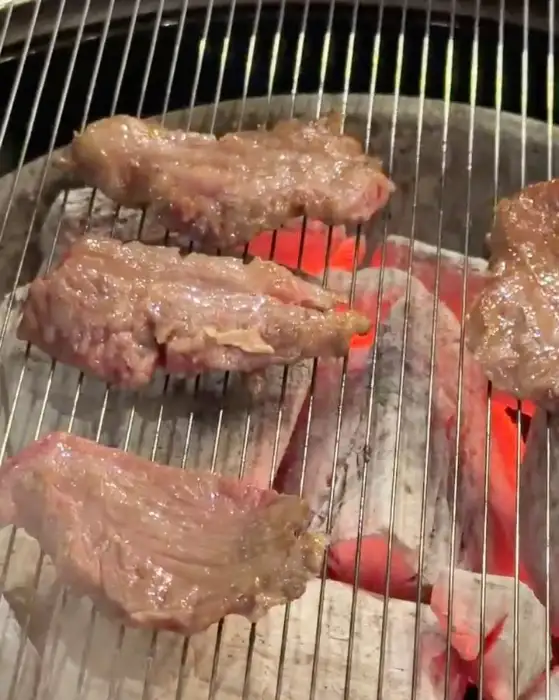 숯불 위에서 맛있게 익어가는 한우 조각들