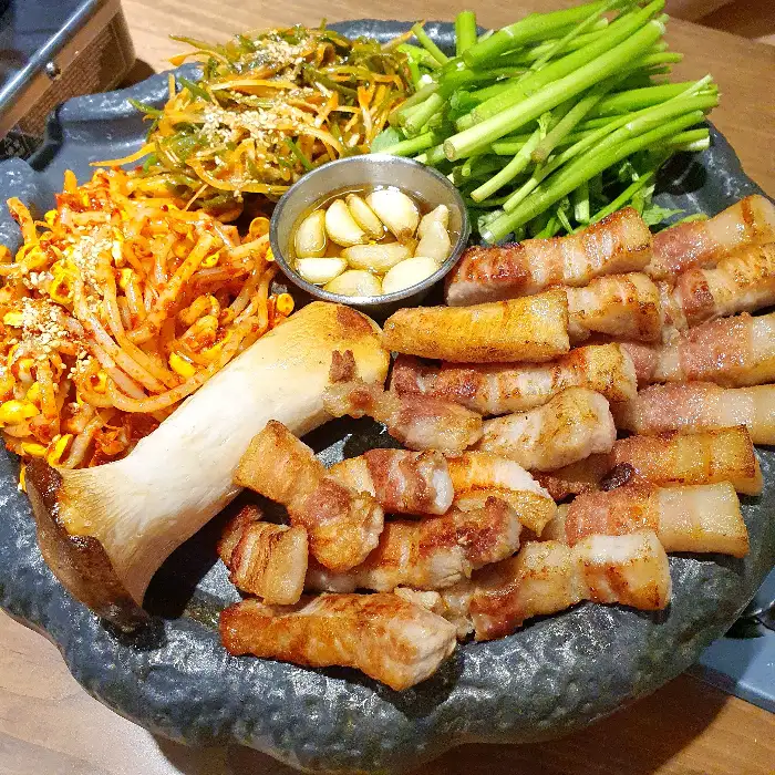 삼겹살과 함께 제공된 다양한 곁들임 채소와 버섯