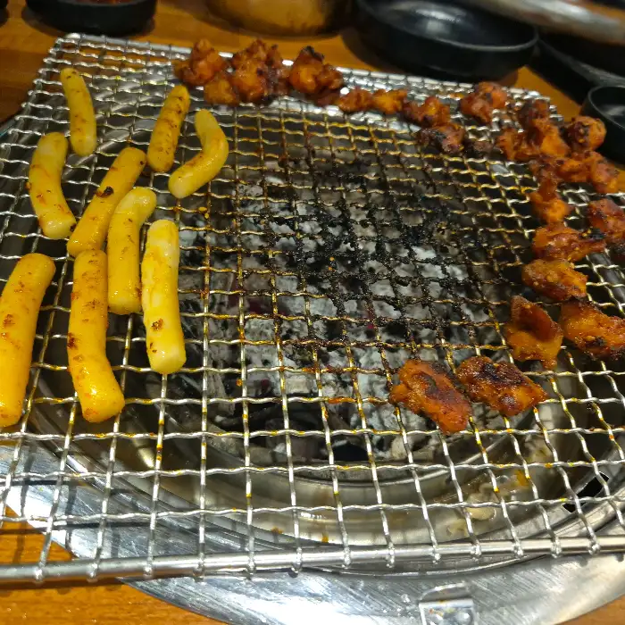 숯불 위에서 익어가는 닭구이와 떡