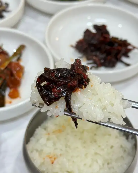 밥 위에 반찬을 올려 먹는 모습