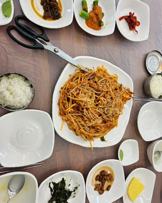 테이블 위에 놓인 뽈찜과 밥, 그리고 각종 반찬