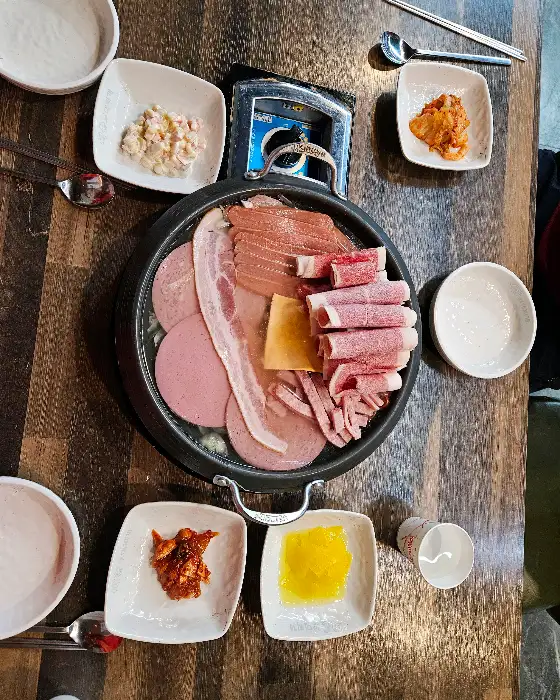 부대찌개가 끓고 있는 모습과 밑반찬