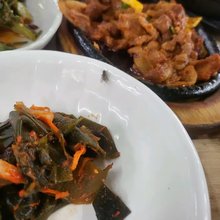앞접시에 담긴 신선한 쌈채소와 제육볶음