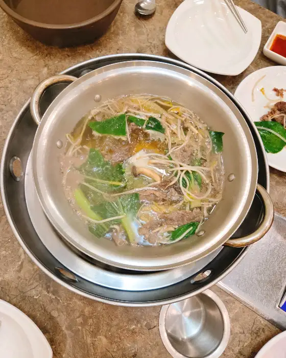 진한 육수와 건더기가 어우러진 샤브샤브 냄비