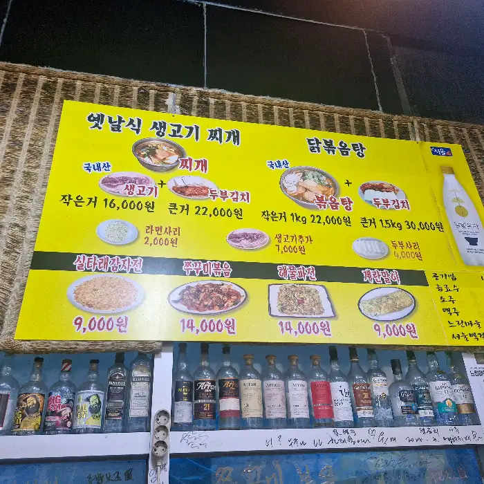 노란색 메뉴판에 다양한 찌개와 볶음 요리, 전 요리 사진이 있다.