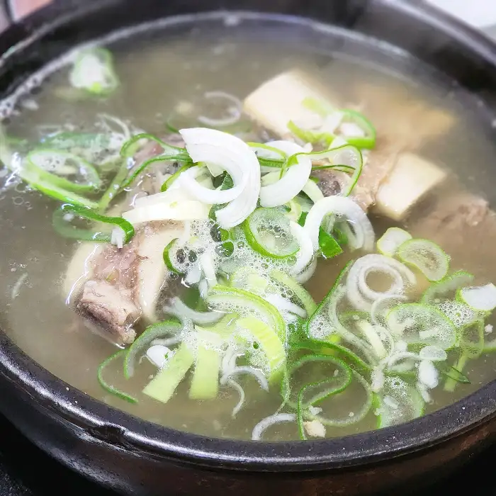 갈비탕 속의 소갈비, 맑은 국물, 파채, 그리고 밥이 함께 담긴 모습