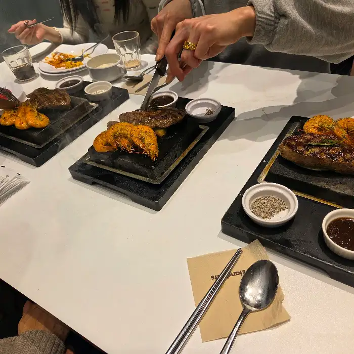 핫플레이트에 담긴 스테이크와 새우 요리