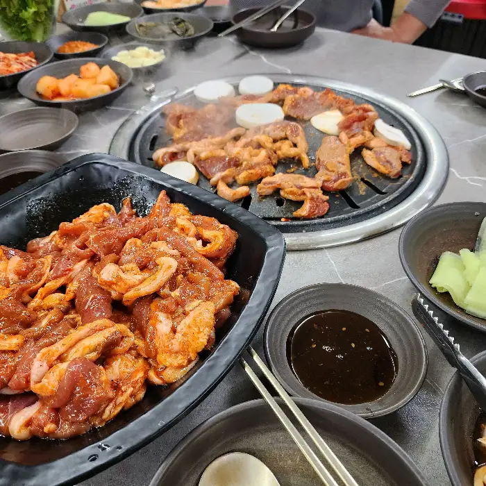 오리탕이 끓고 있는 모습과 함께 여러 반찬이 차려진 테이블