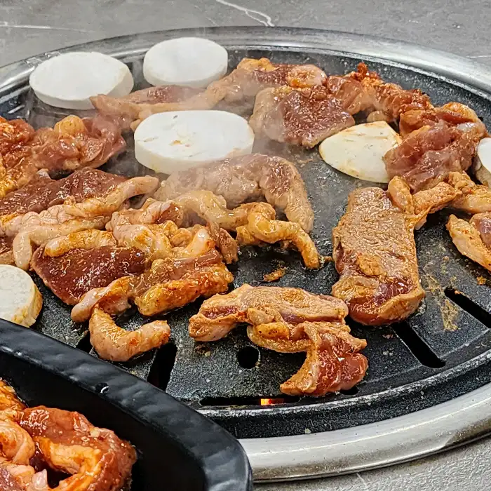 오리 로스 구이가 불판 위에서 맛있게 익고 있는 모습