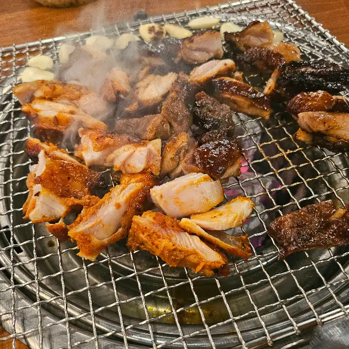 숯불 위에서 구워지는 다양한 닭고기 부위