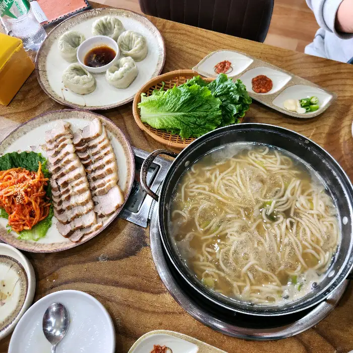 칼국수, 수육, 만두가 푸짐하게 차려진 모습