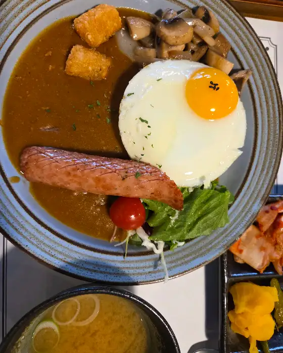 반숙 계란 프라이와 소세지, 버섯이 올라간 카레