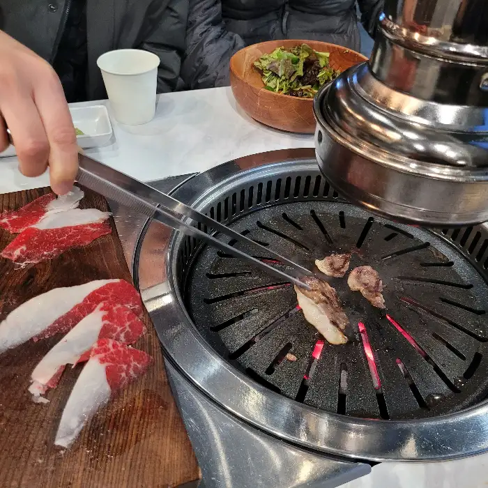 신선한 한우 차돌박이와 안심이 나무 도마 위에 놓여 있는 모습