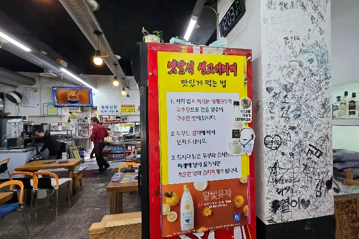 김치찌개가 담긴 뚝배기와 밥, 반찬들이 보인다.