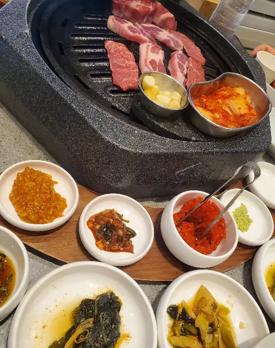 다양한 밑반찬들이 테이블 한가득 차려져 있습니다. 정갈하고 먹음직스러운 비주얼입니다.