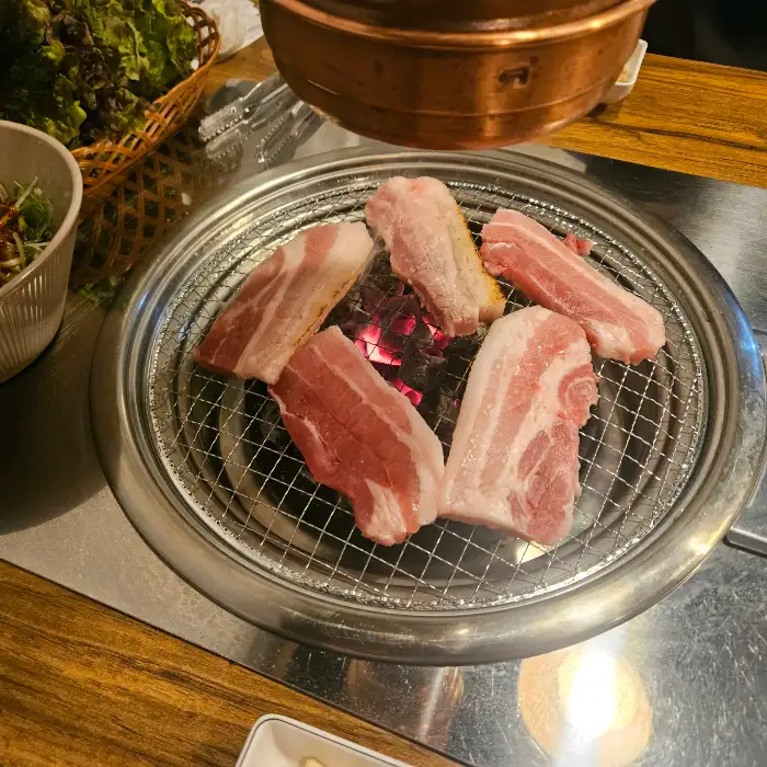 숯불 위에서 노릇하게 구워지는 삼겹살
