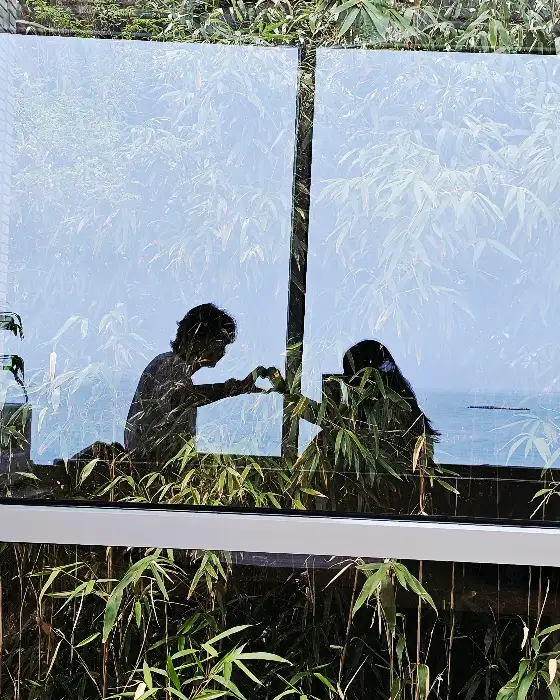 통창 너머로 보이는 바다와 창가에 앉아있는 사람들