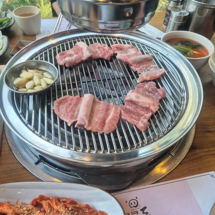 숯불 위에서 익어가고 있는 두툼한 갈비 조각들