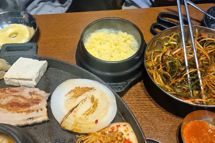 솥뚜껑 위에서 함께 구워지는 김치와 콩나물