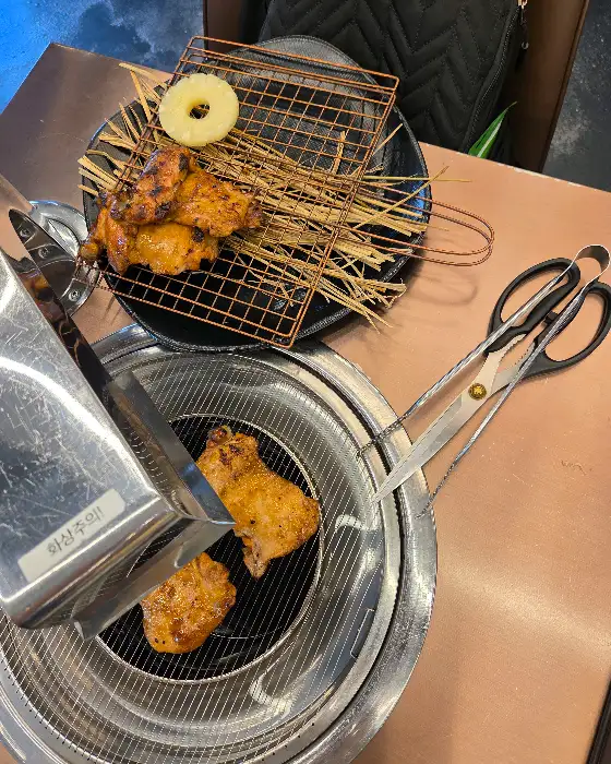 석쇠 위에서 구워지고 있는 닭갈비와 파인애플 조각