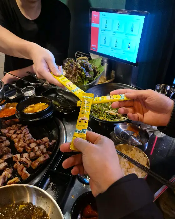 직원이 쌈장과 고기를 건네주는 모습