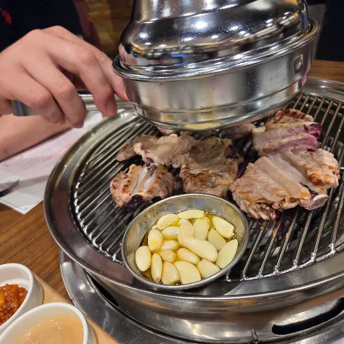 갈비가 익으면서 숯불 위에서 나는 연기와 함께 먹기 좋게 잘라지는 모습
