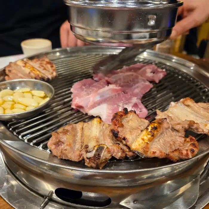 숯불 위에서 다양한 부위의 고기들이 익어가고 있는 모습