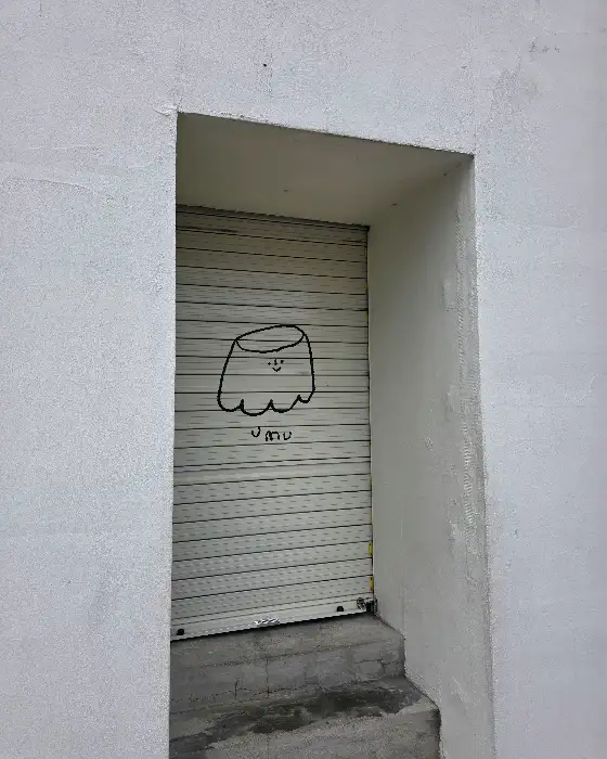 우무 동문시장점 출입문의 셔터에 그려진 푸딩 캐릭터 그림