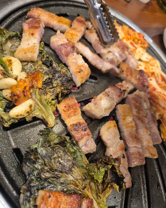 쌈 채소와 함께 구워진 삼겹살