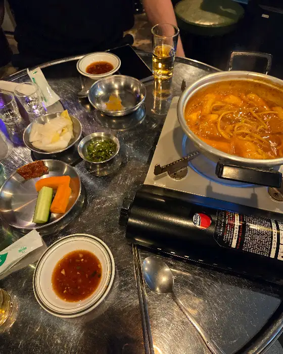 식탁 위에 놓인 냄비와 앞접시, 소스 등