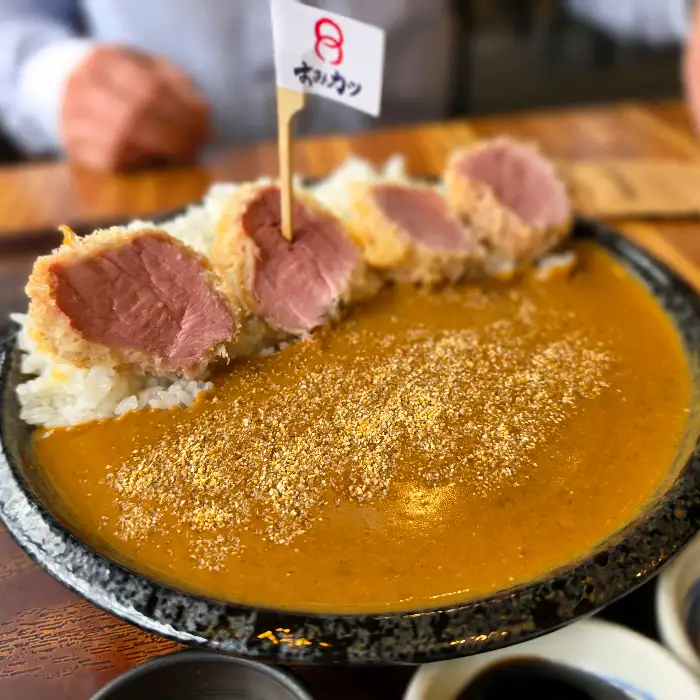 밥 위에 돈까스 조각과 카레가 올라간 모습