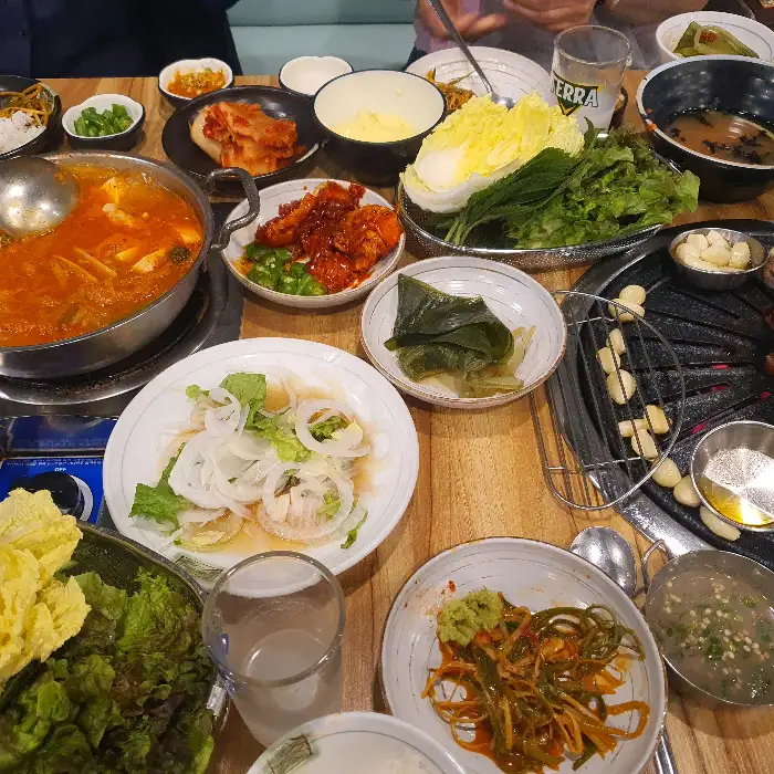 다양한 쌈 채소와 곁들임 메뉴가 준비된 테이블