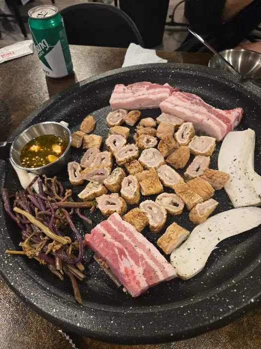막창과 삼겹살, 그리고 곁들임 채소와 소스가 함께 담긴 모습
