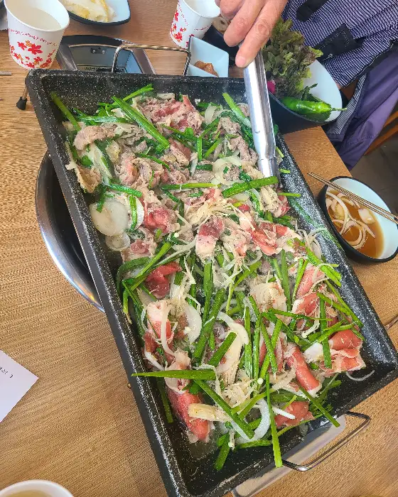 잘 익은 오리불고기를 쌈 채소와 함께 먹는 모습.