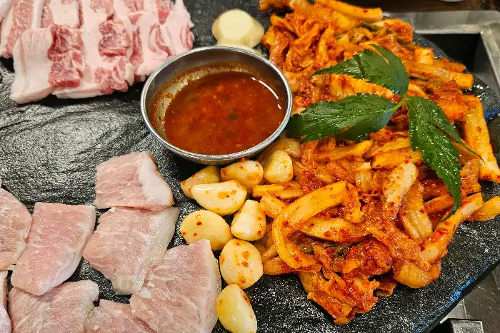 돌판 위에서 익어가는 삼겹살과 마늘