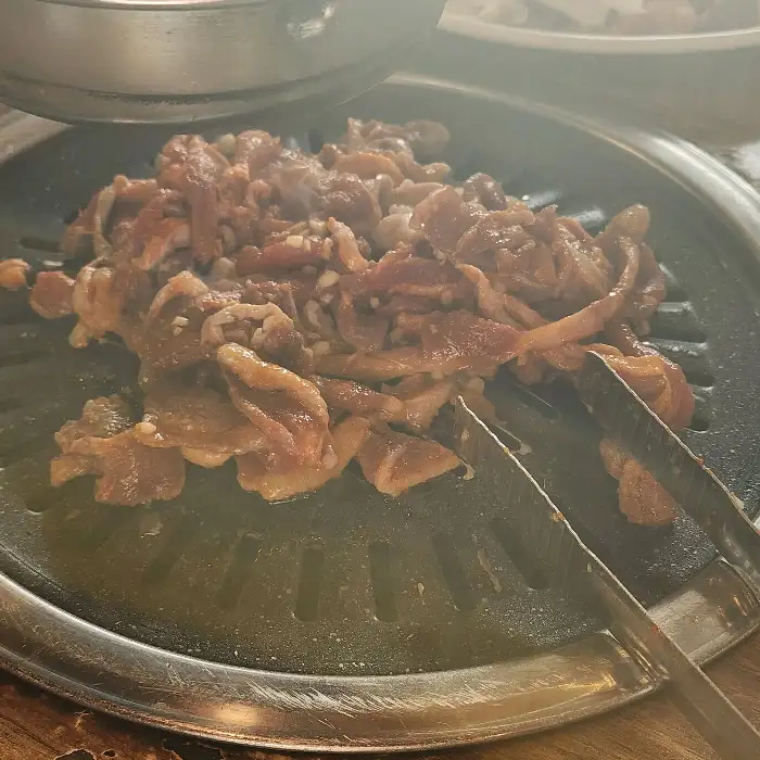 불판 위에서 지글지글 익어가는 마늘양념오리구이