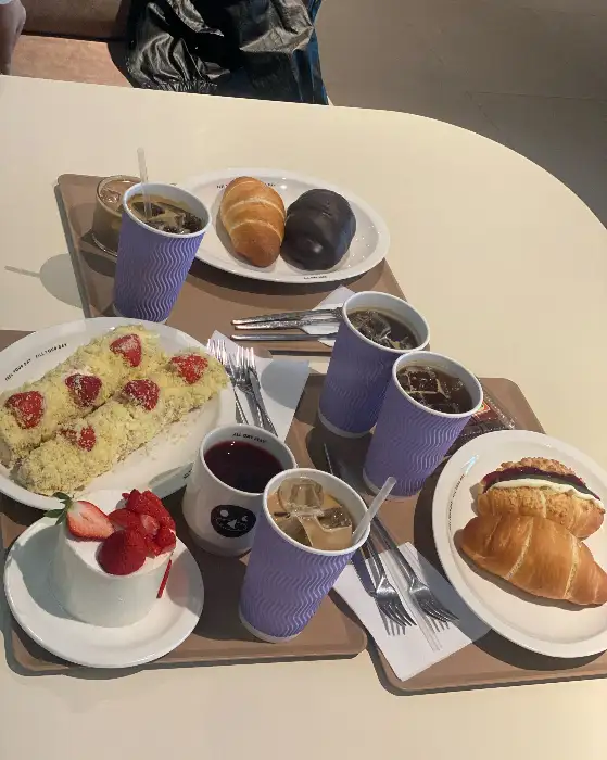 테이블 위에 놓인 커피, 빵, 케이크 등 다양한 메뉴