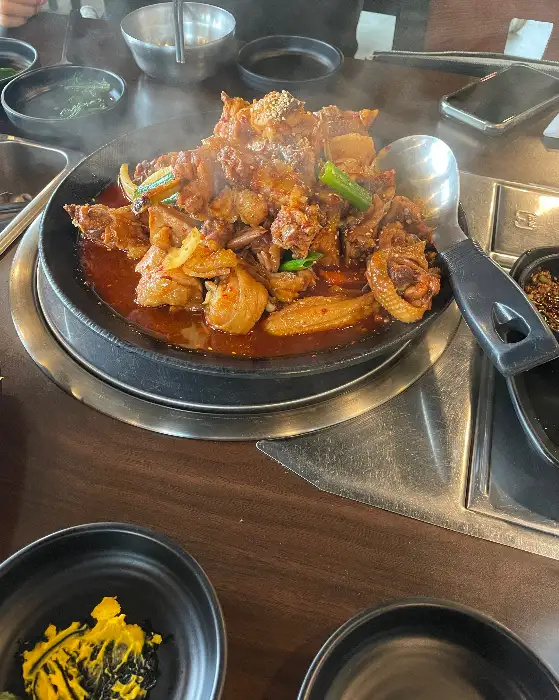 오리 불고기가 담긴 철판과 주변의 반찬들