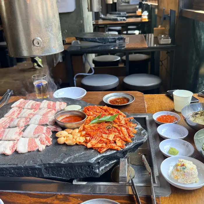 거대한 돌판 위에 올라간 신선한 삼겹살과 김치